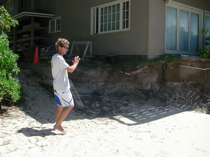 Scott Young, showing foundation of house affected by beach erosion, N. Shore of Maui, Speckesville beach