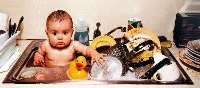 baby in kitchen sink with dishes