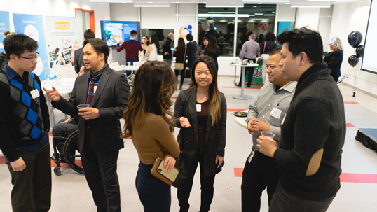 Individuals networking in a busy indoor setting.