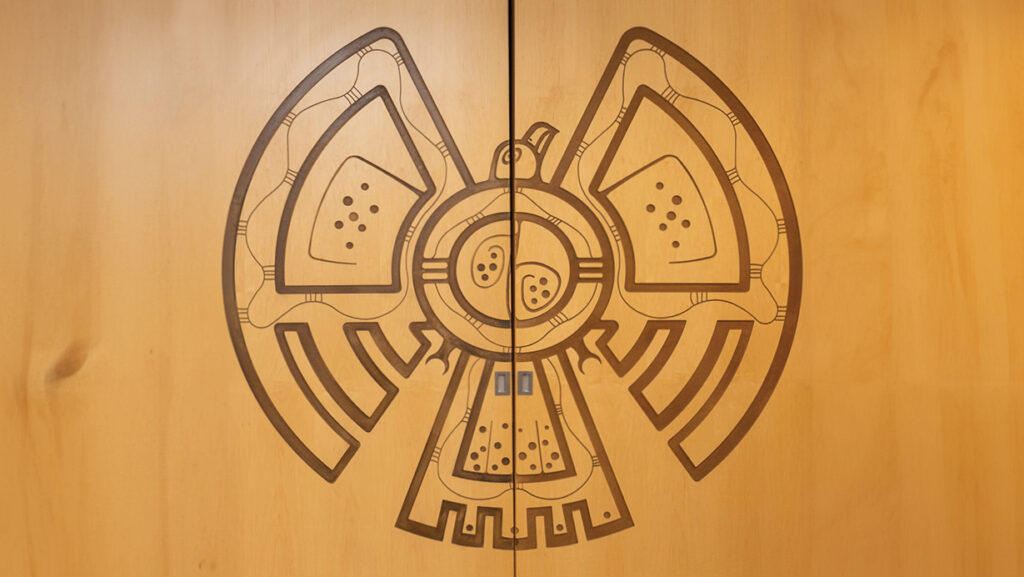A carving of an indigenous styled eagle on two panel doors