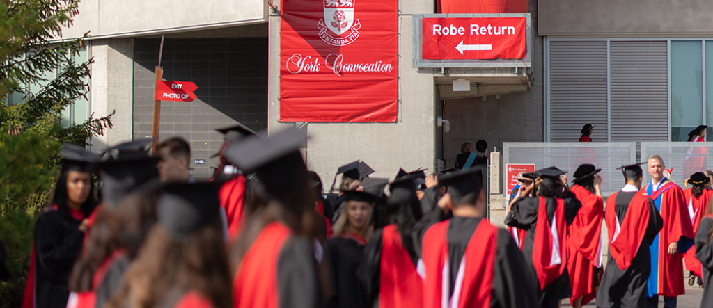 Graduate procession outside of Sobeys Stadium with the York Convocation banner in the background