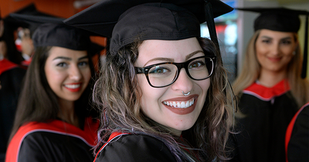 Woman smiling in her cap and gown 