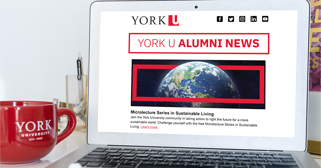 Laptop with York U Alumni newsletter on the screen and a Mug with the York U logo on the left 