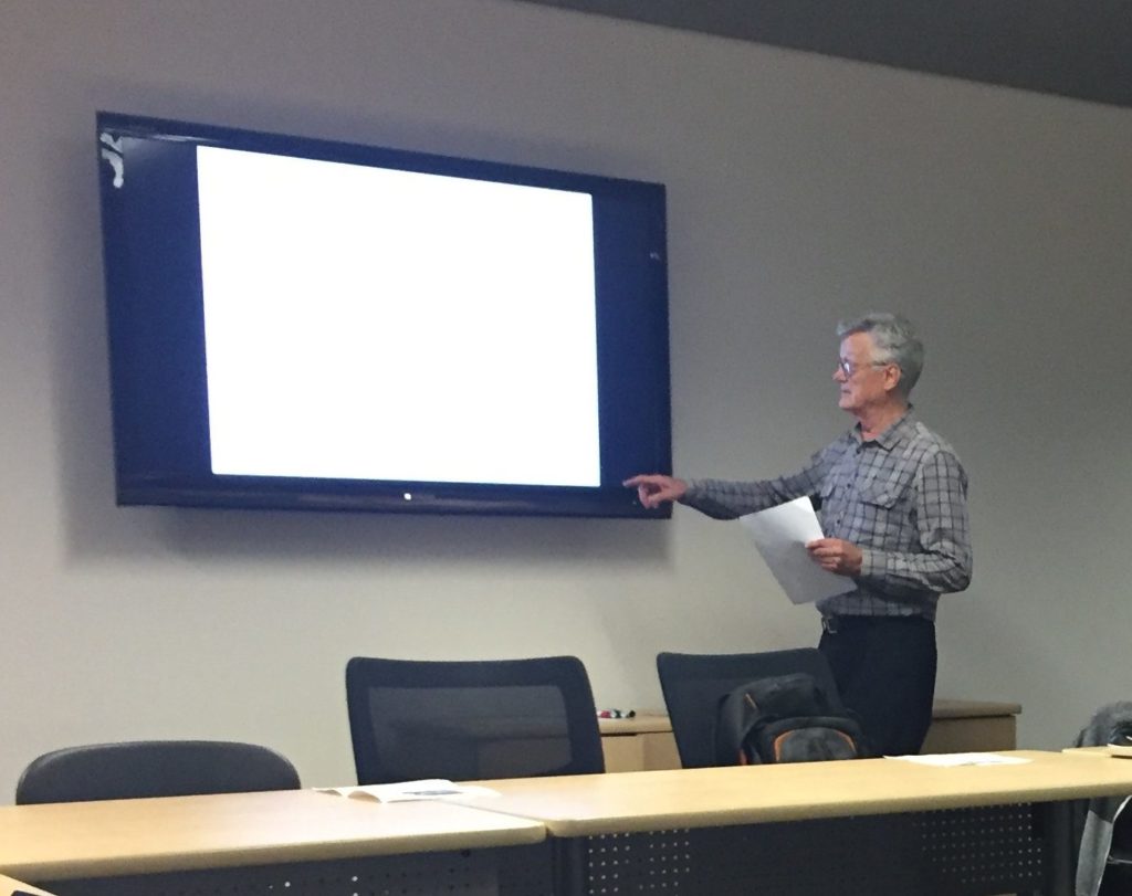 Dr. Simon Bekker presenting a paper facing a screen