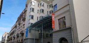 A row of office blocks with an awning and flags at the entrance to the home of the Master Alterveilles program.