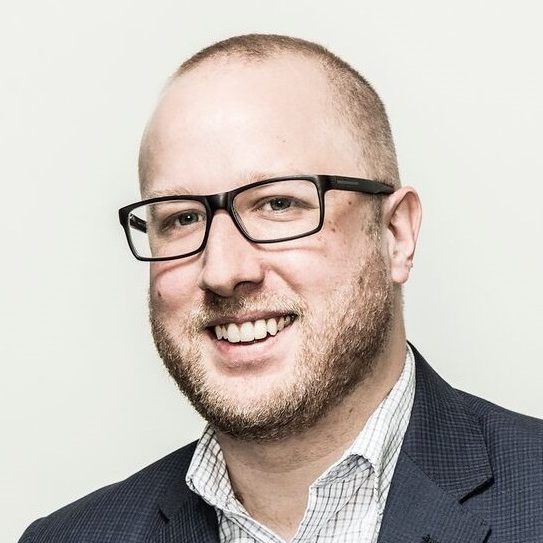 Kevin Gingerich smiling and with black eyeglasses