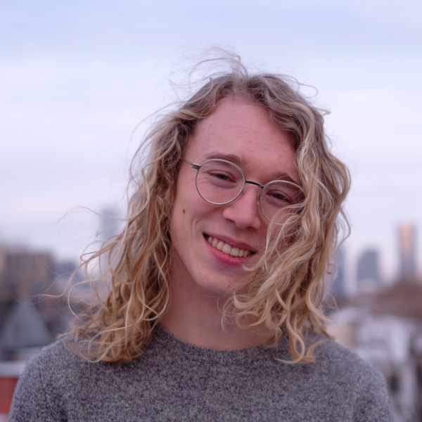Wiley sharp smiling and with eyeglasses, hair blown by the wind