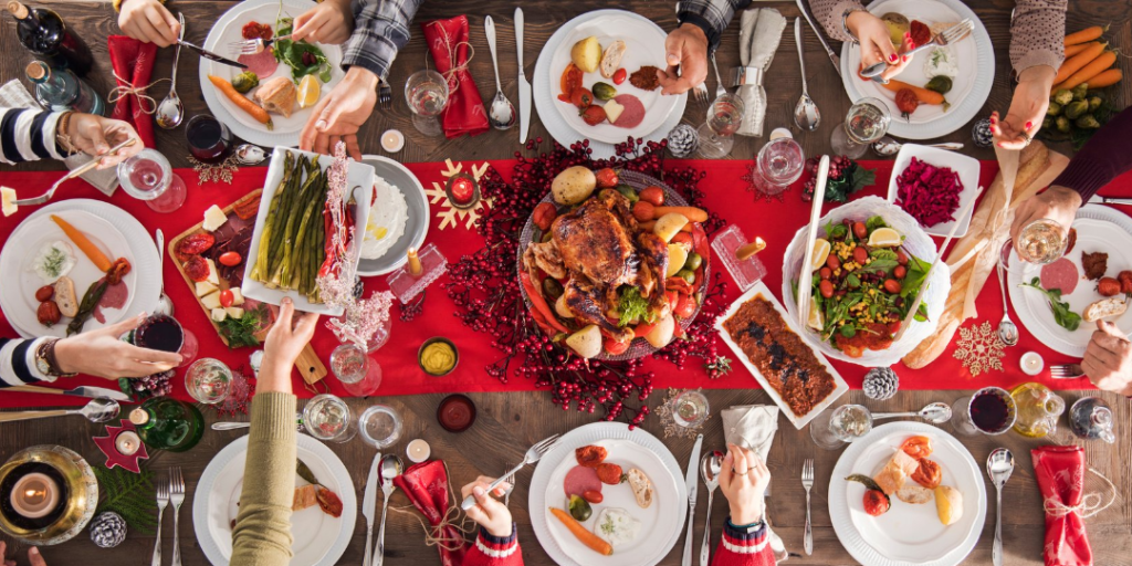 A bird's eye view of a dinner table. People are passing around food.