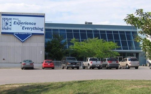 Low-rise concrete and glass building with sign reading "Canlan Ice Sports: Where the Experience is Everything"