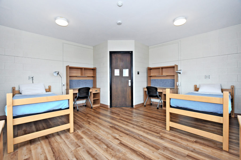 Interior of Tatham Hall. A double room showing two beds, and two desks with chairs.
