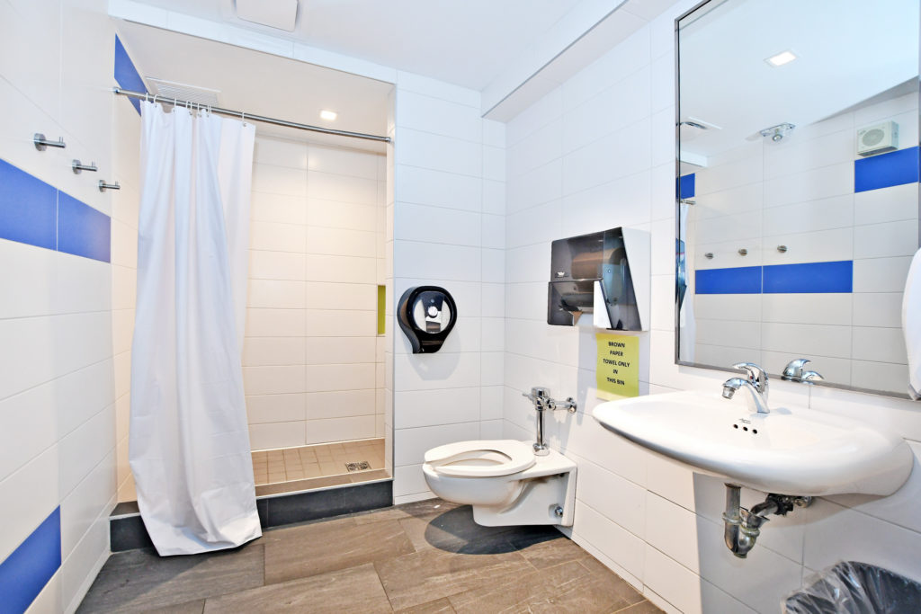 Interior of Vanier Residence semi-private washroom showing toilet, shower, sink.
