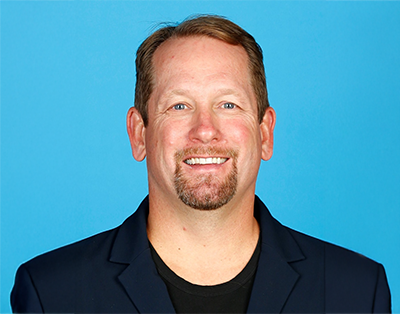 Image of Nick Nurse in a dark shirt with light blue background