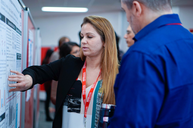 Person points to a poster in front of spectators