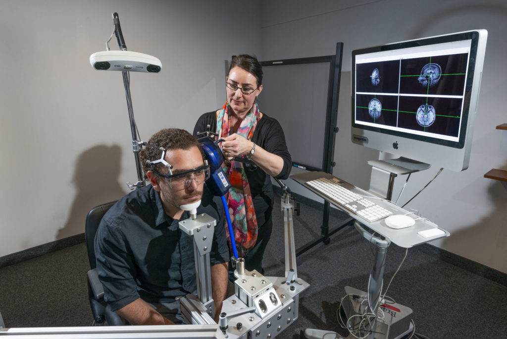 The TMS setup. Image shows the subject and experimenter.