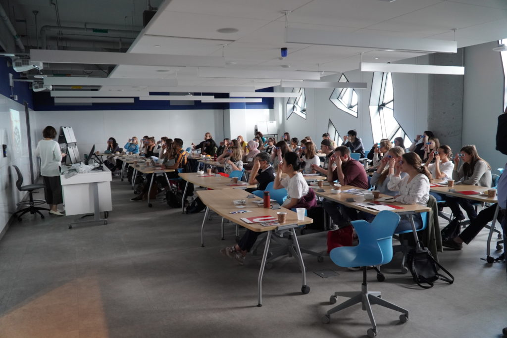 Participants of the CVR summer school are seated in a classroom, trying out anaglyph 3D glasses. 