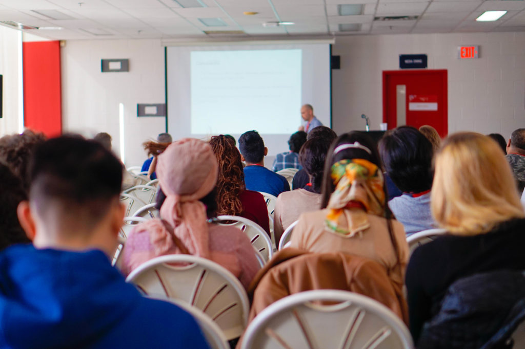 People sitting in a classroom watching a presenter.