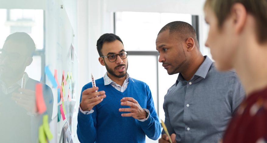 Group of people at work around a whiteboard