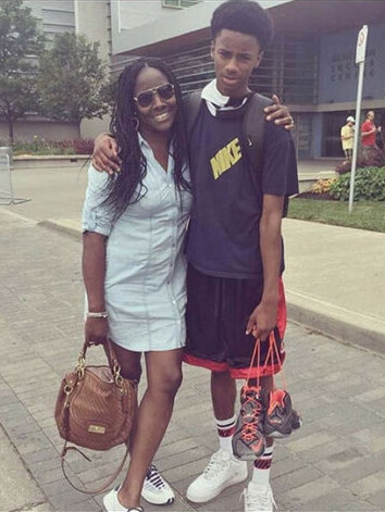 Charline Grant and her son Ziphion standing outside of a building with their arms around each other.