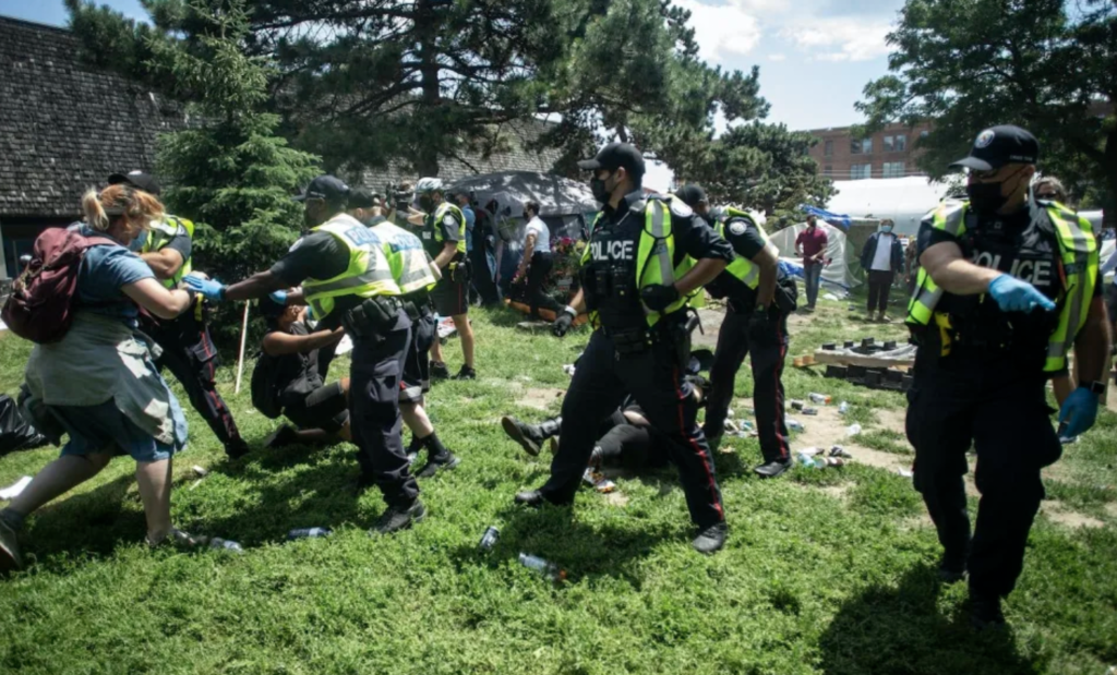 Police remove encampment supporters as they clear the Lamport Stadium Park homeless encampment in Toronto in July 2021 