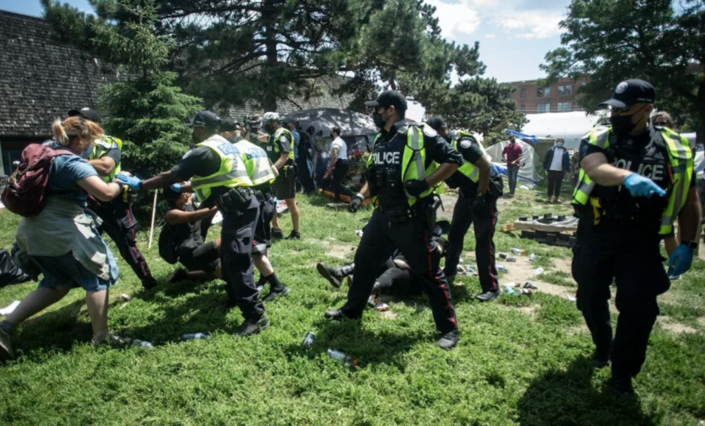 Police remove encampment supporters as they clear the Lamport Stadium Park homeless encampment in Toronto in July 2021