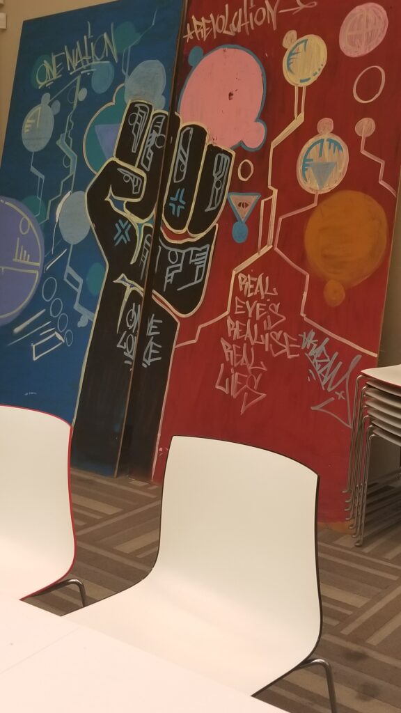 image of a mural with a black fist and wording about systemic injustices