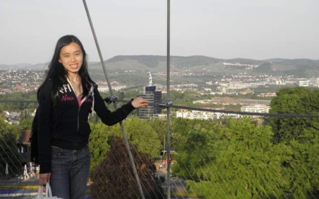 Rubecca standing on a bridge with the town of  Höhenpark Killesberg, Stuttgart in the background in 2011