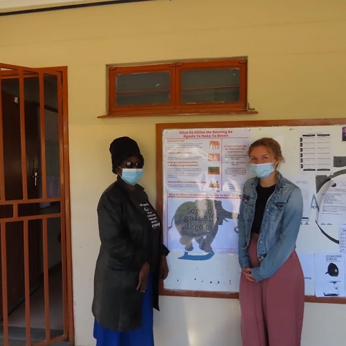 2 girls standing near a poster 