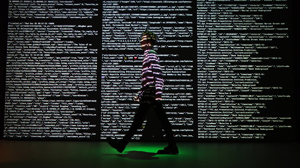 line of code over a man walking by a screen being projected