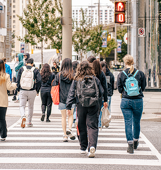 A group of student crossing the street taken from behind