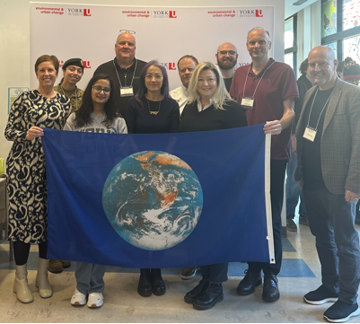 group of people holding poster of Earth