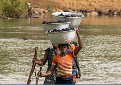 People putting a bucket on their head and crossing a river