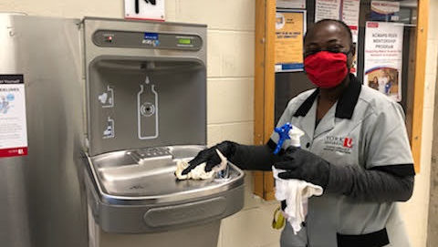 Custodial staff sanitizing hydration station