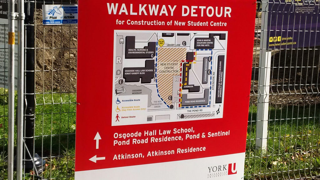 Detour sign with map, attached onto fence