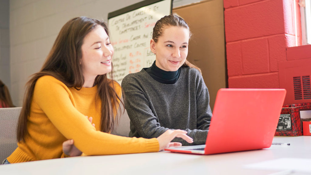 Two students looking at a laptop