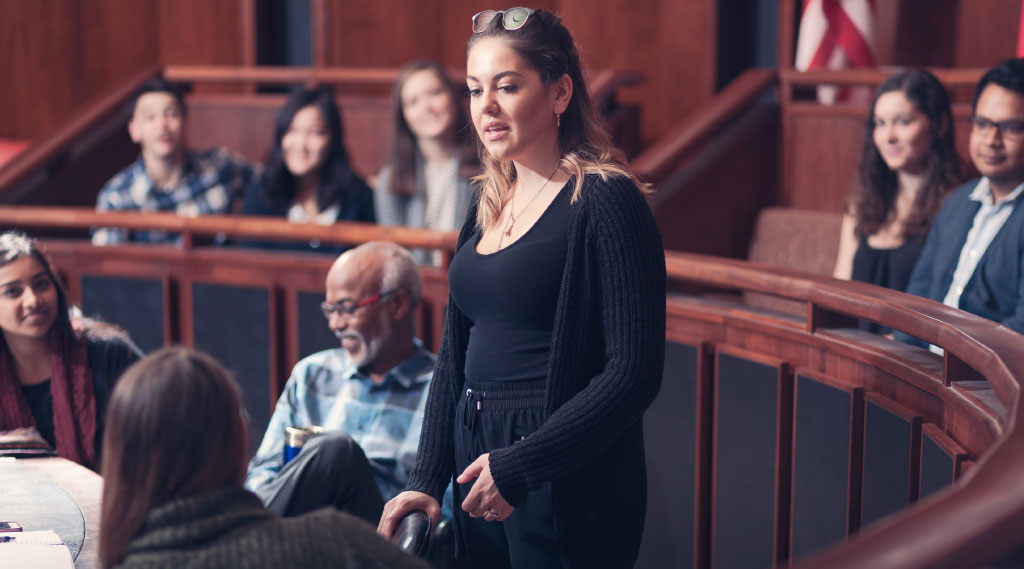 A female student speaks in front of a group of people.