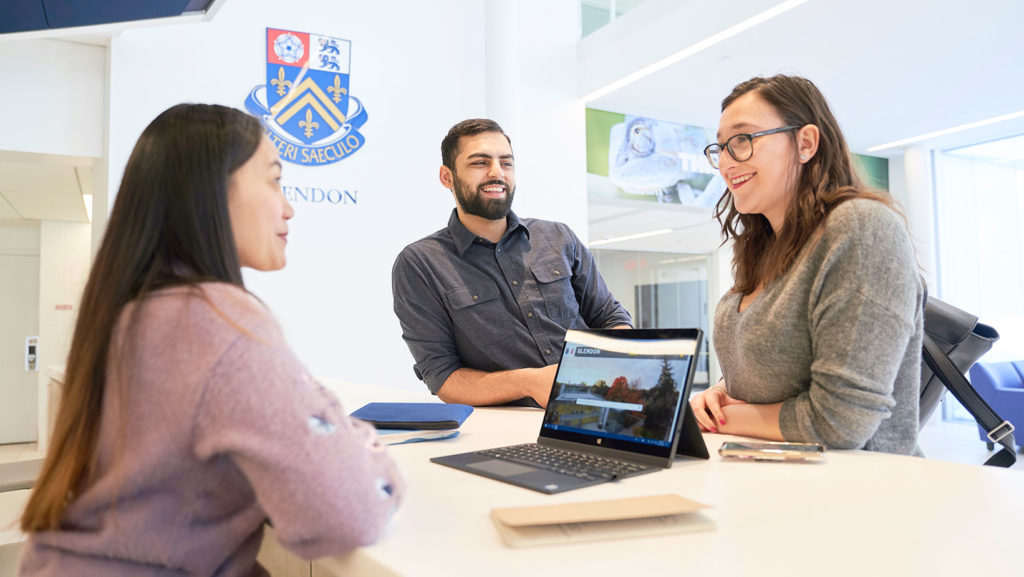 Three students are discussing at a table