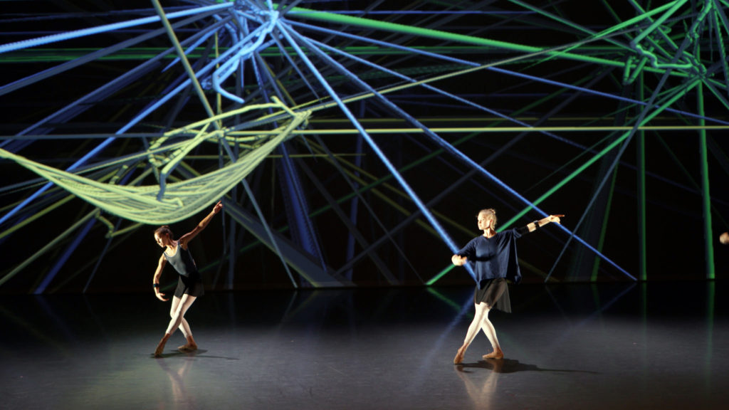 two dancers until a neon-lit superstructure