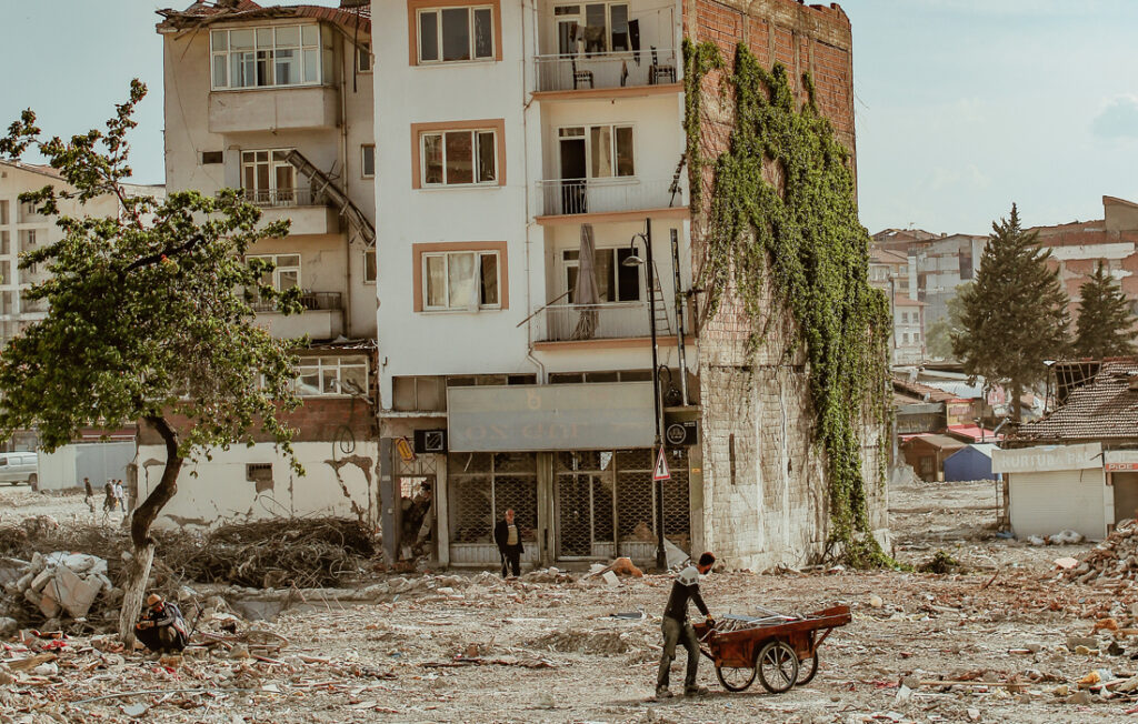 a man cleans up outside a damaged building