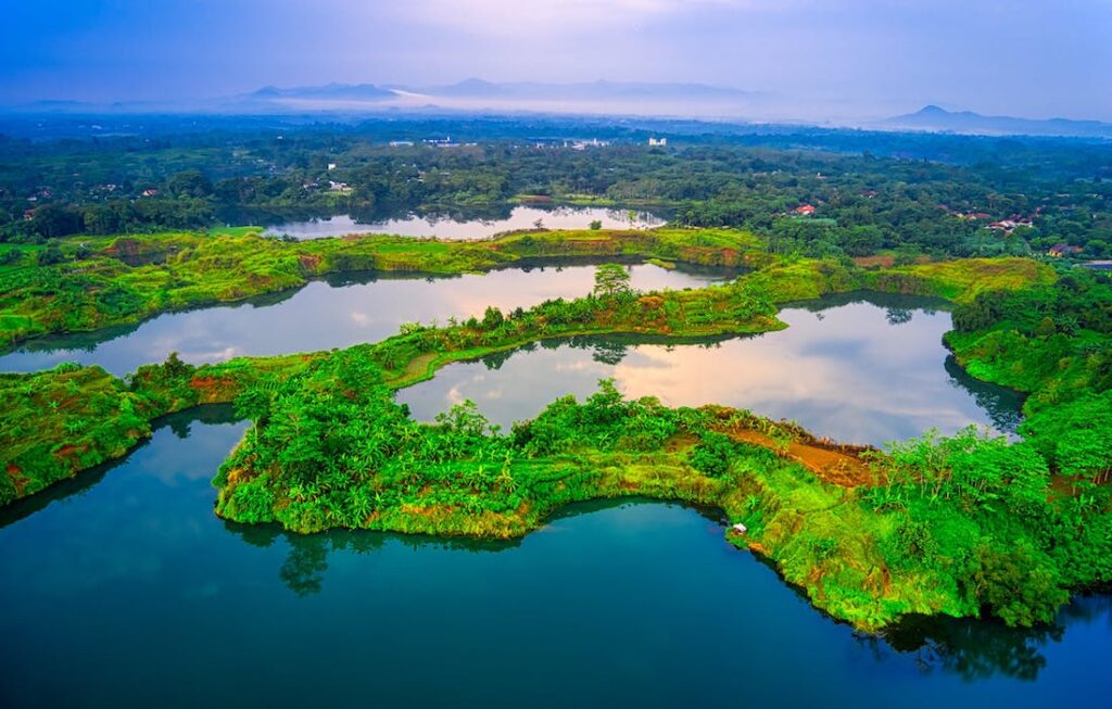 aerial view of a tropical landscape with lush green surrounded by small bodies of water