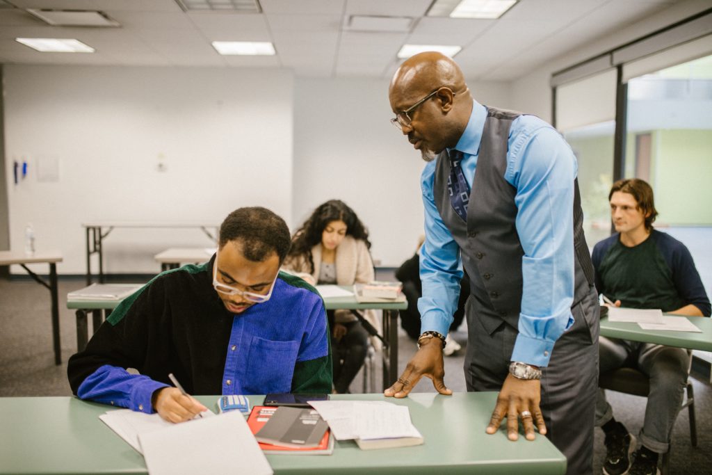 An image of a teacher proctoring his students during an examination