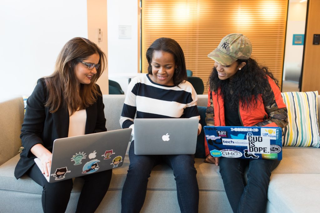 Photo of three woman in front of laptop computer