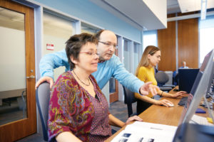 People looking at a computer monitor