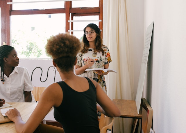 Woman Discussing in Front of Other Women.