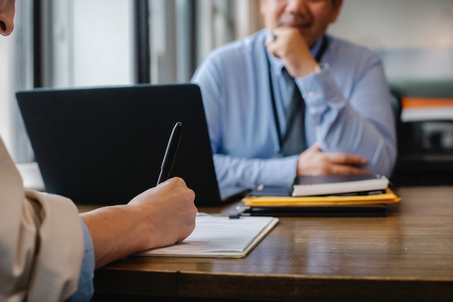 Photo of a woman filling an application form in office
