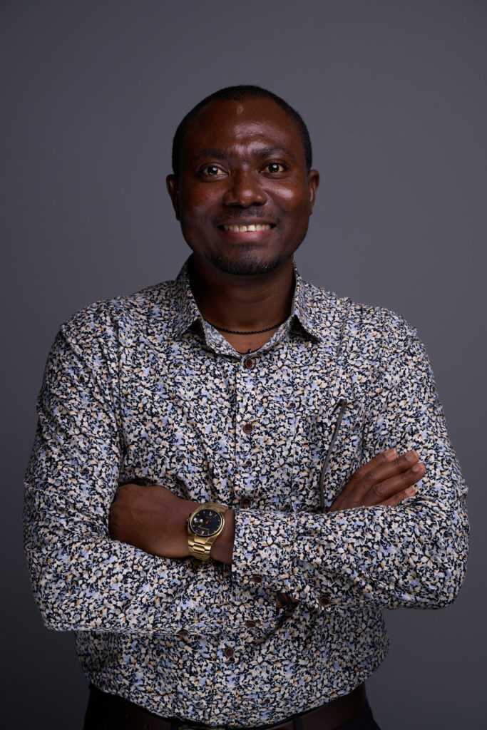 Felix Amanor Otu smelling in black background