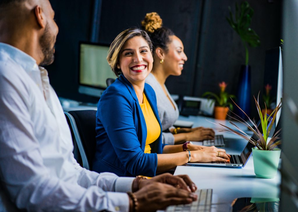 woman smiling at man as they work in office