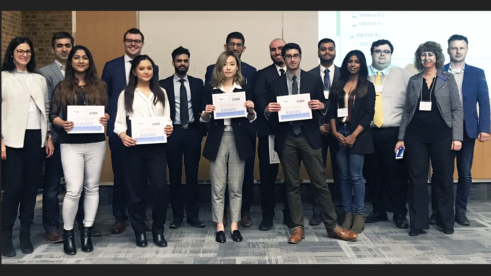 The winners of the PACC Challenge accept their award alongside event judges and PACC faculty.
Front row: Arpita Haque Bhuiya (winning team), Marianne Martinez (winning team), Charlene Lv (winning team), Zakir Bhatia (winning team) and Sharmela Sivanayagam (judge). Back row: Sandra Iacobelli (faculty), Syed Banoori (judge), David Marsillo (judge), Ammar Faizy (judge), Alam Khandwala (judge), Johnathan Ishak (winning team), Parth Shah (judge), David Catarino (judge), Joanne Jones (faculty) and Bartosz Amerski (faculty)