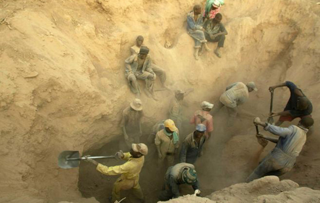 photo of an artisanal pit mine with workers using shovels