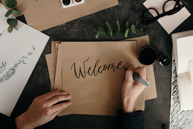 An image of a person writing on brown paper