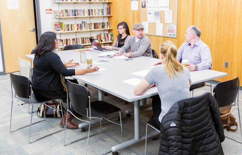 photo of a small group of people working at tables